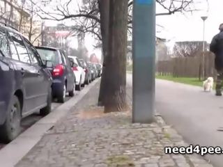 Half naked brunette pissing behind a building